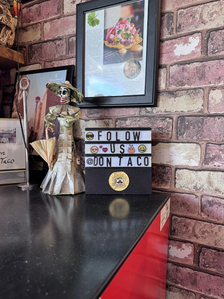Don Taco Calgary counter with Catrina figurine and framed press feature