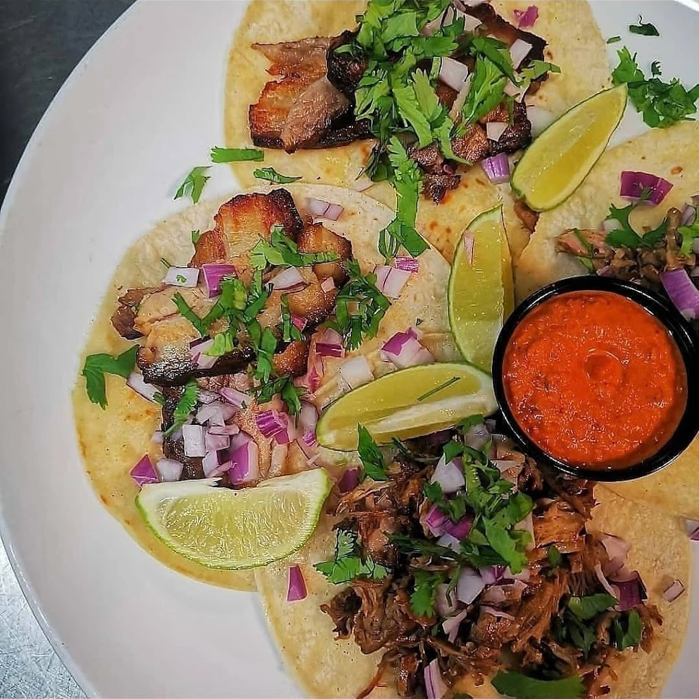 Pork belly chicharron and carnitas tacos with lime and salsa roja at Don Taco Calgary